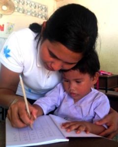 A child learning to write with the new teacher at the Migrant Education Program in Kuraburi Phang Nga Thailand